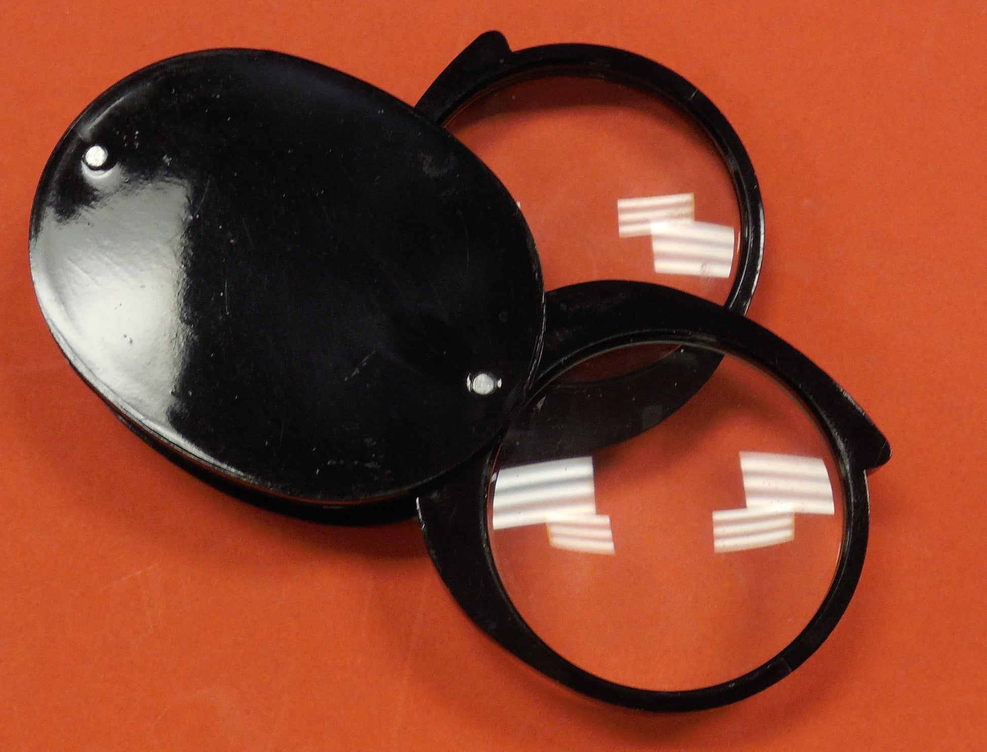 A pocket magnifier that has 2 lenses for optimal magnification. They fold into a black plastic casing