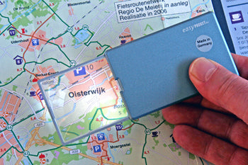 A hand using the pocket magnifier to look at a location on a map